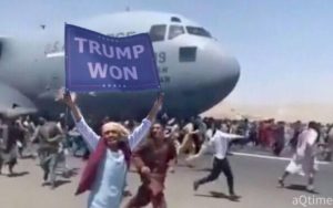 man holding up sign kabul airport runway transport plane