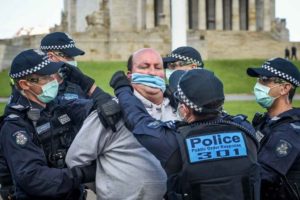 victoria australia lockdown protest police restrain man with mask