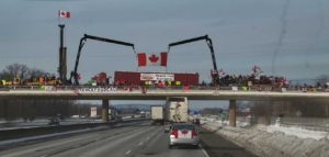 canada trucker protest convoy overpass supporters truck frudeau signs