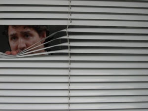 justin trudeau looking through window blinds